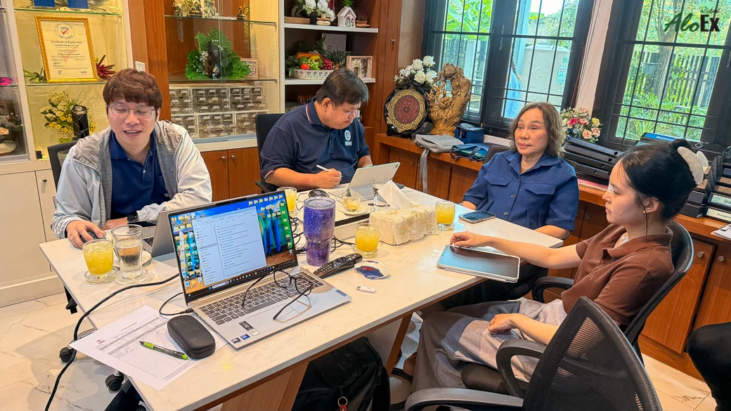 The AloEx team meeting at a work table with the brand’s certificates and awards displayed behind them