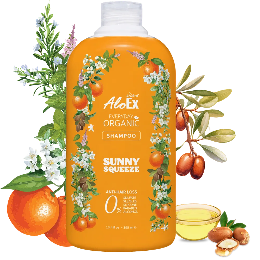被鲜花、柑橘与摩洛哥坚果环绕的 AloEx Everyday Organic Shampoo Sunny Squeeze 瓶身